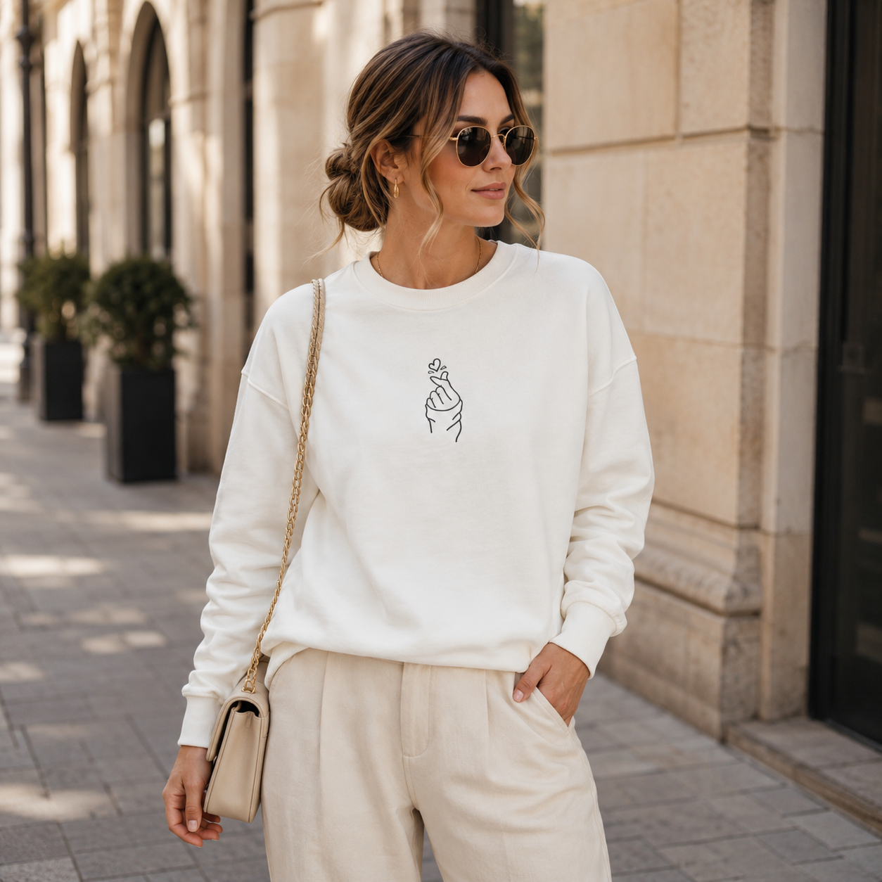 Embroidered sweatshirt with a hand and heart symbol.