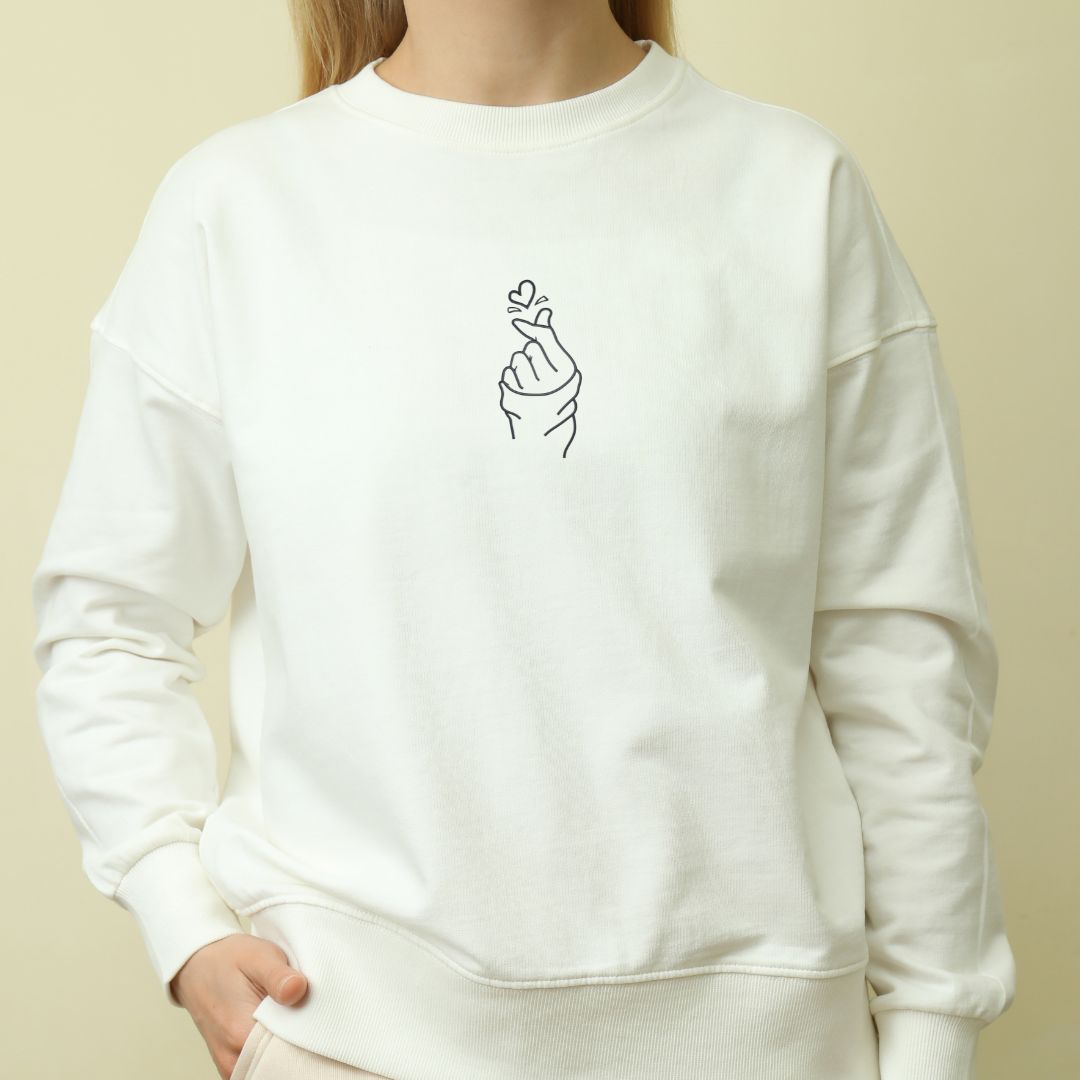 Siuvinėtas džemperis su rankos ir širdelės simboliu.